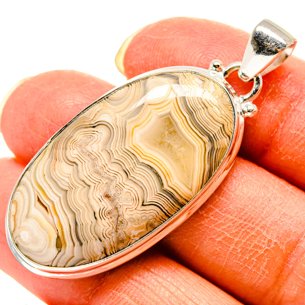 Sterling silver teardrop agate pendant with lace-like banded stone center and hinged bail