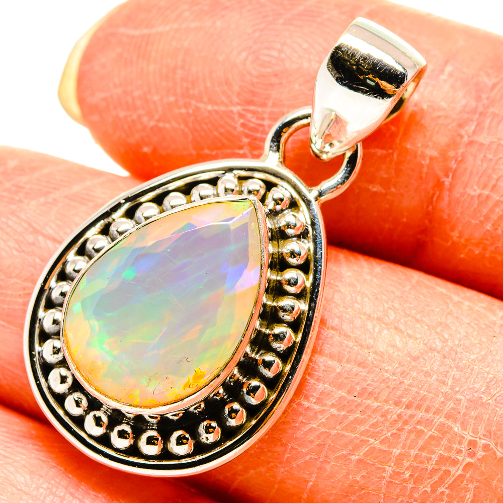 Faceted opal teardrop pendant with gold-tone beaded halo bezel