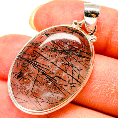 Oval tourmalinated quartz pendant with clear stone and red-black needle pattern