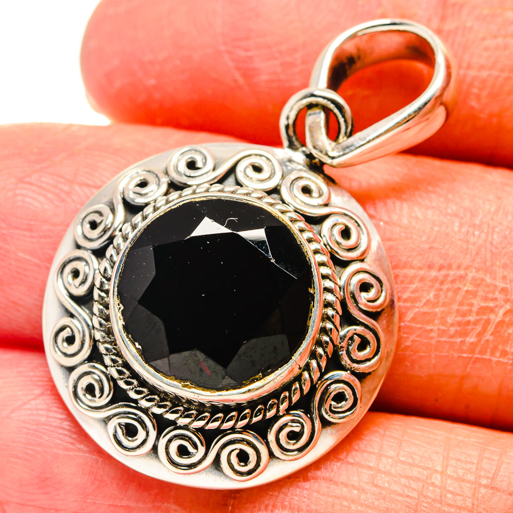 Round sterling silver pendant with red garnet cabochon, scroll filigree, hinged bail
