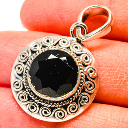 Round sterling silver pendant with red garnet cabochon, scroll filigree, hinged bail