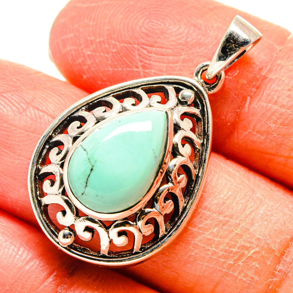 Turquoise teardrop pendant with ornate silver filigree bezel and loop bail