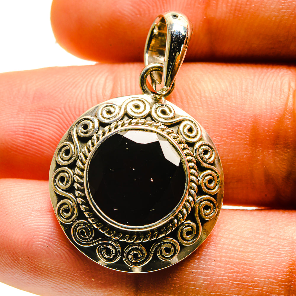 Sterling silver garnet pendant with round dark red gemstone and scrollwork border