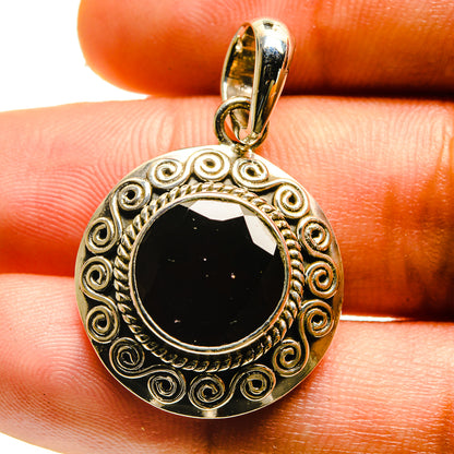 Sterling silver garnet pendant with round dark red gemstone and scrollwork border