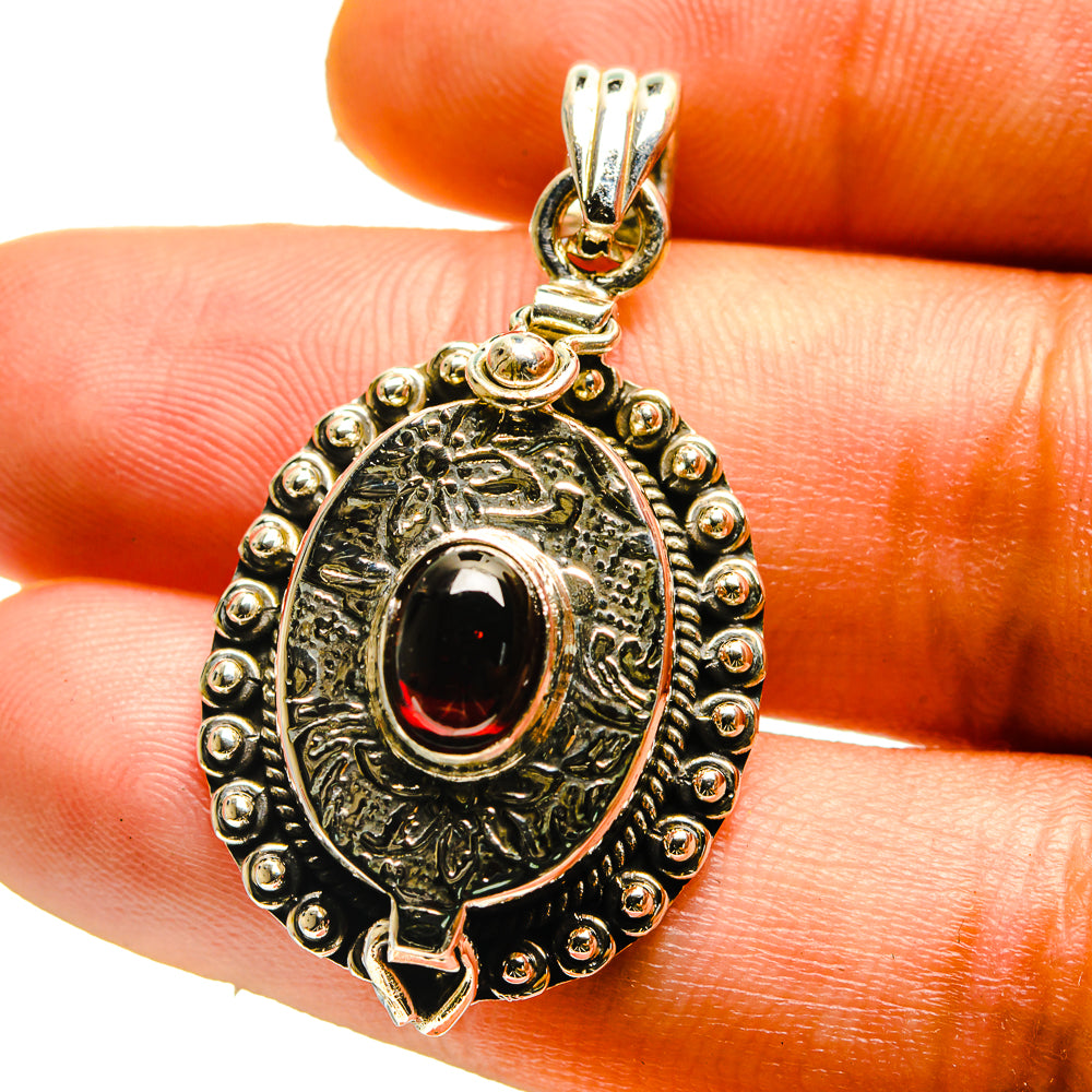 Sterling silver pendant with round garnet red center stone and ornate beaded border