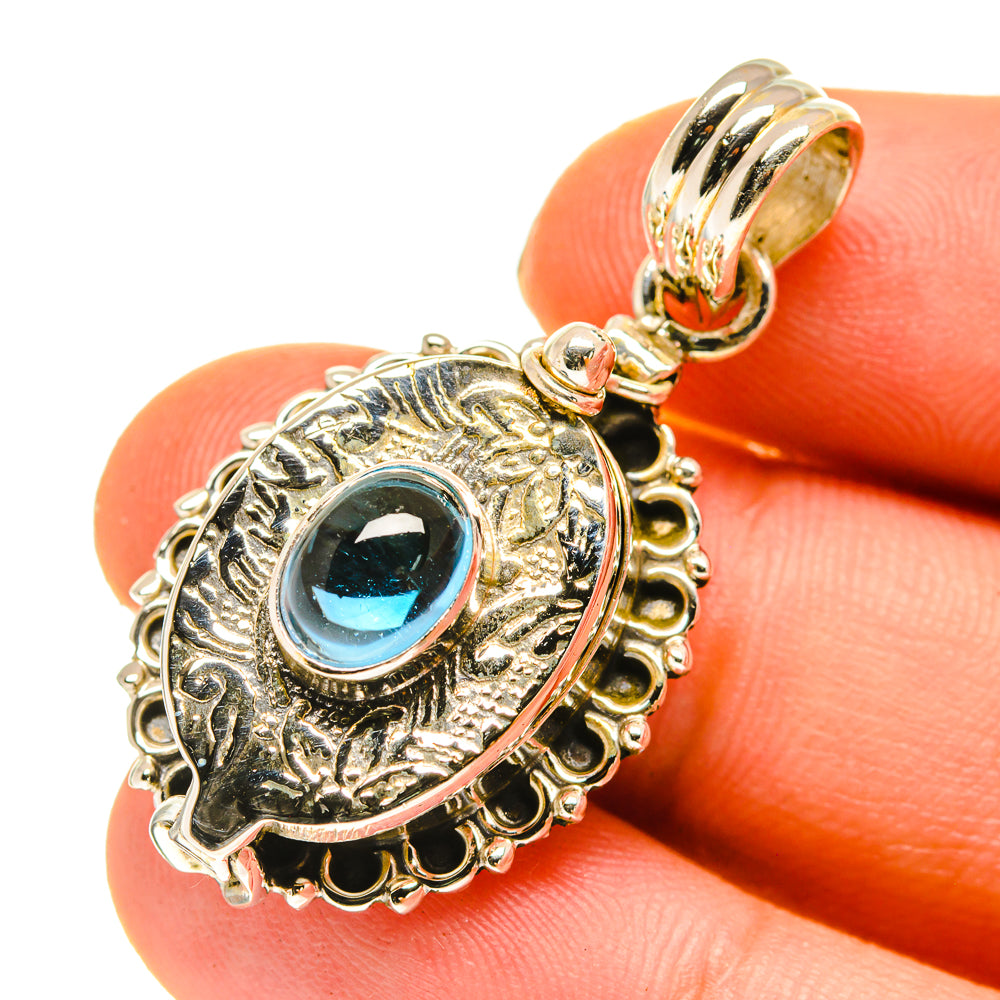 Sterling silver poison pendant close-up with blue oval gemstone in engraved frame