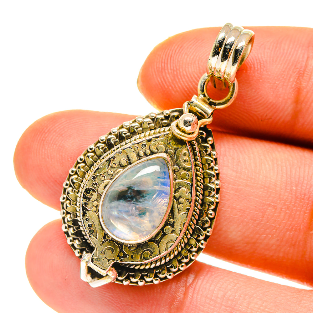 Teardrop moonstone pendant with bail, ornate gold-tone border and iridescent cabochon