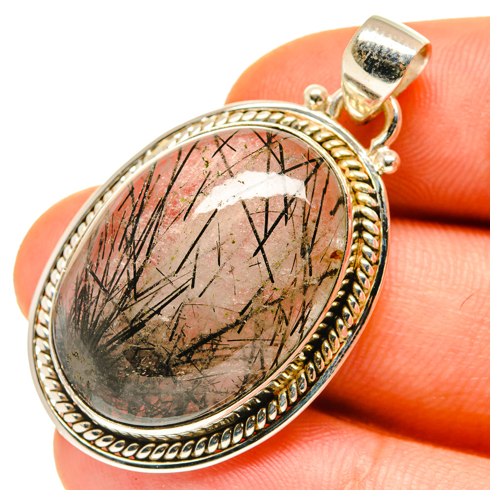 Oval tourmalinated quartz pendant with black needle inclusions, gold-tone silver bail.