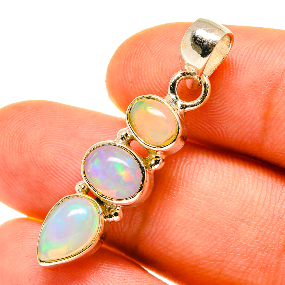 Opal pendant close-up with iridescent oval stones in gold-tone sterling silver bezel