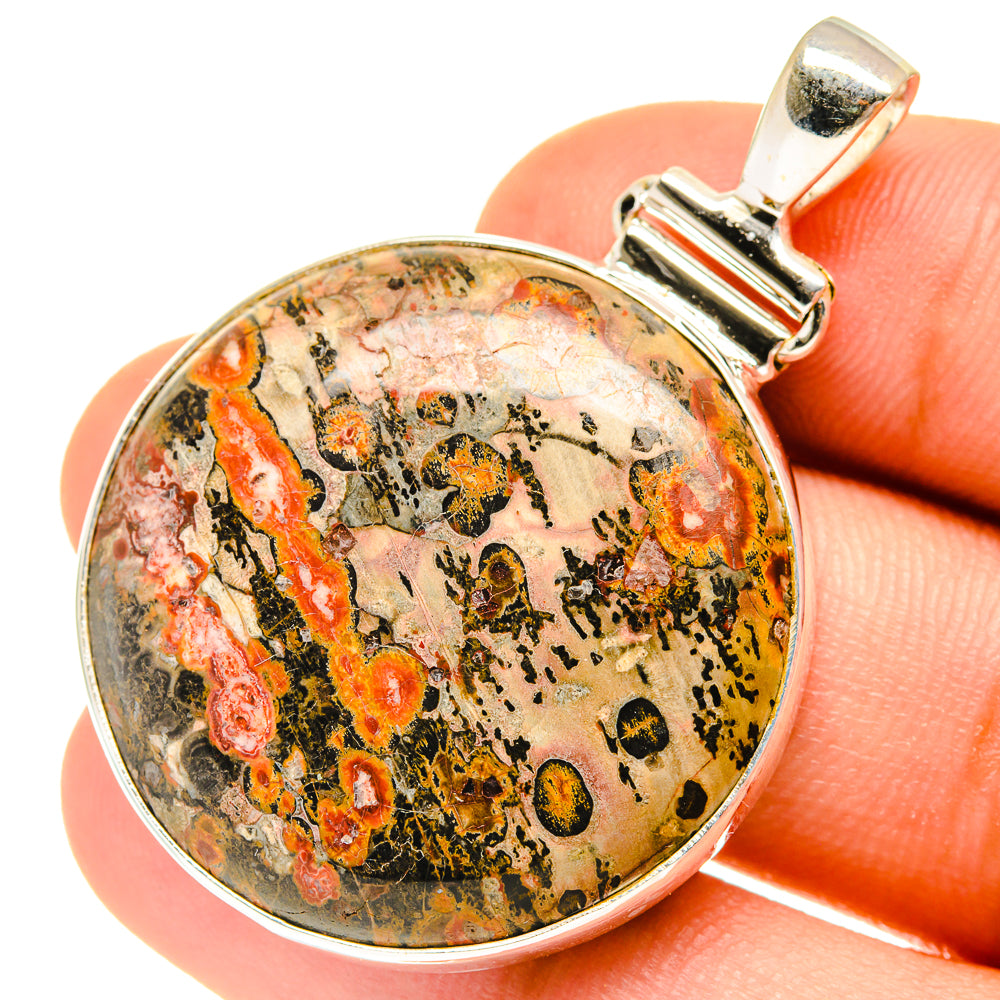 Round poppy jasper pendant close-up, multicolor stone in silver-toned frame and bail