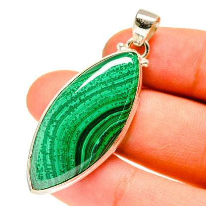 Malachite in chrysocolla pendant close-up, green oval stone in 925 sterling silver setting.
