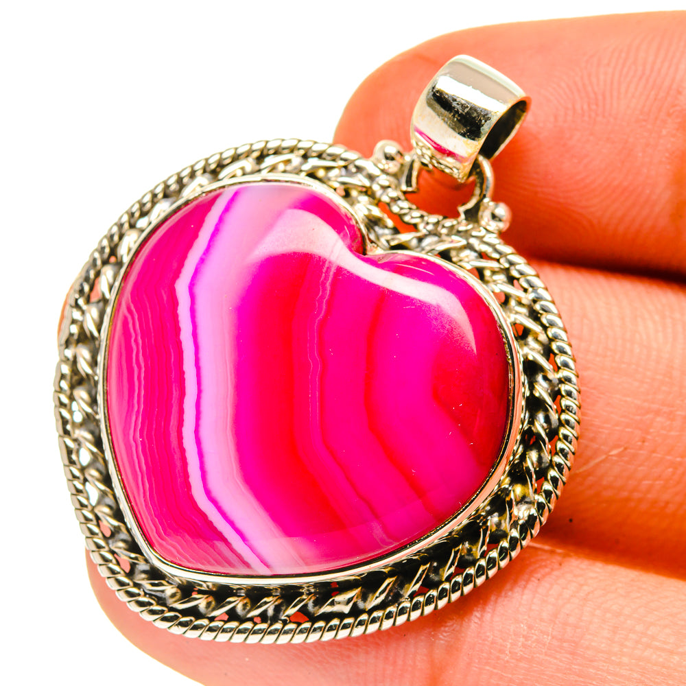 Heart-shaped pink agate pendant with braided-edge silver frame and bail