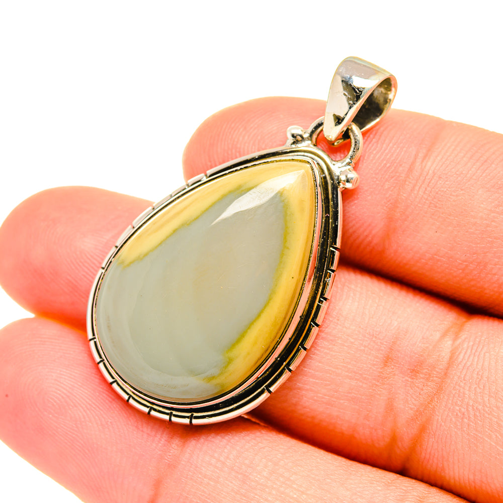 Jasper teardrop pendant close-up with silver bezel and bail, glossy pale yellow cabochon.