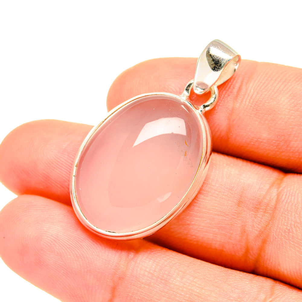 Rose quartz pendant with pink oval cabochon set in 925 sterling silver, close-up.