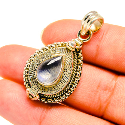 Moonstone pendant on finger, teardrop rainbow cabochon in ornate 925 sterling silver