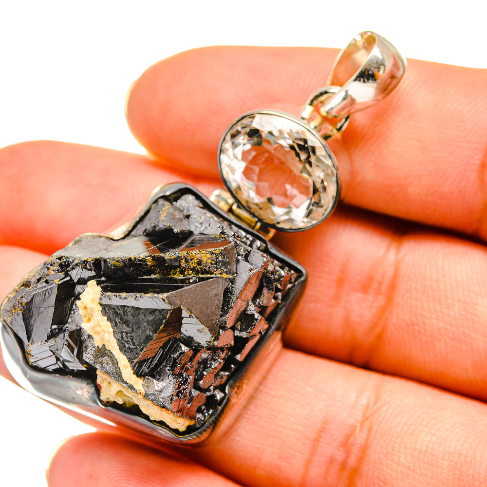 Rough shungite pendant with clear oval quartz, gold-tone bail and stone inlay detail