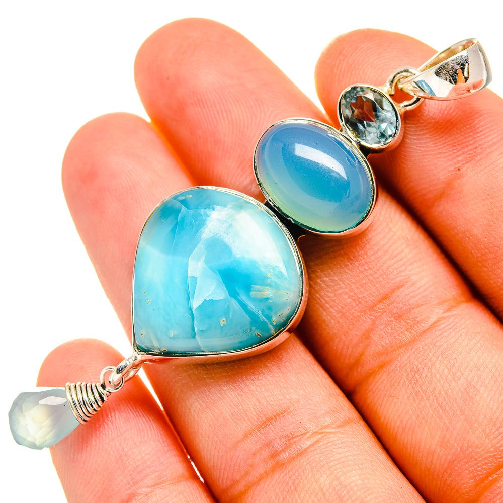 Sterling silver pendant with two heart-shaped aqua and blue stones and blue gem accents