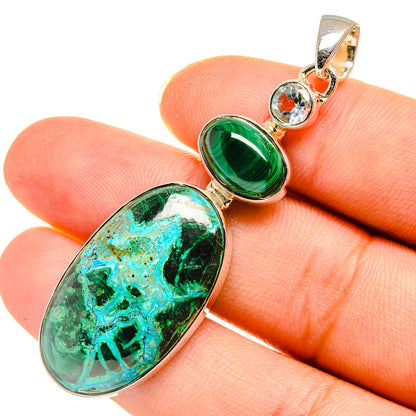 Green oval pendant on fingertip with silver bail and round blue accent stones