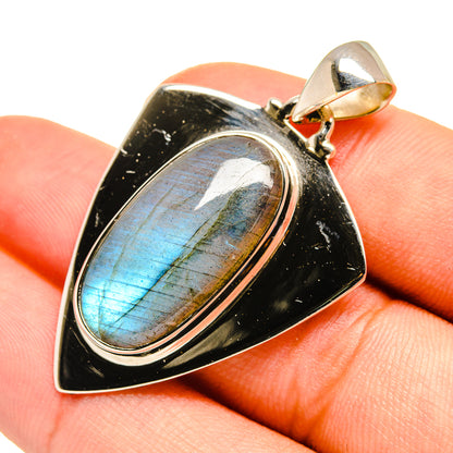 Labradorite pendant with oval blue flash stone, silver bezel and bail on dark backing