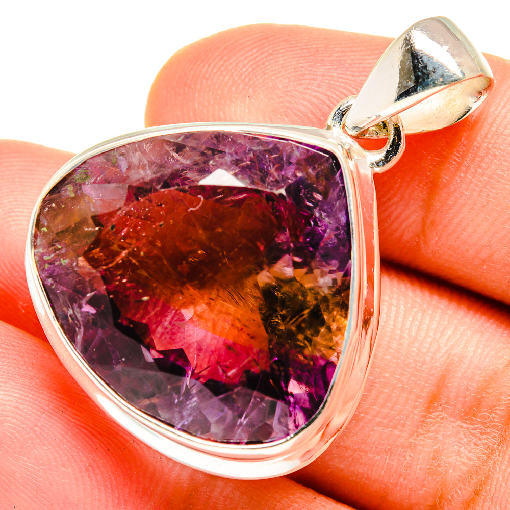 Faceted teardrop ametrine pendant with sterling silver frame and bail, on finger