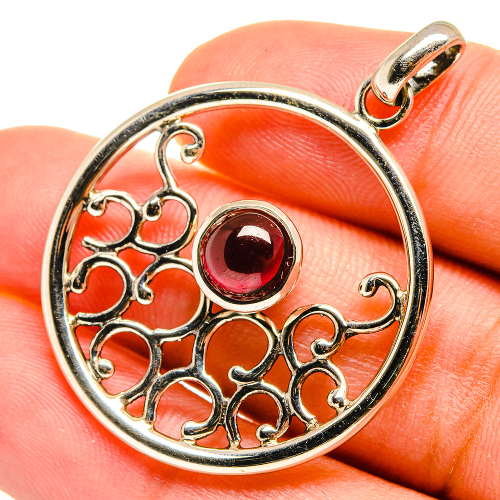 Sterling silver round garnet pendant with ornate openwork and dark red gemstone