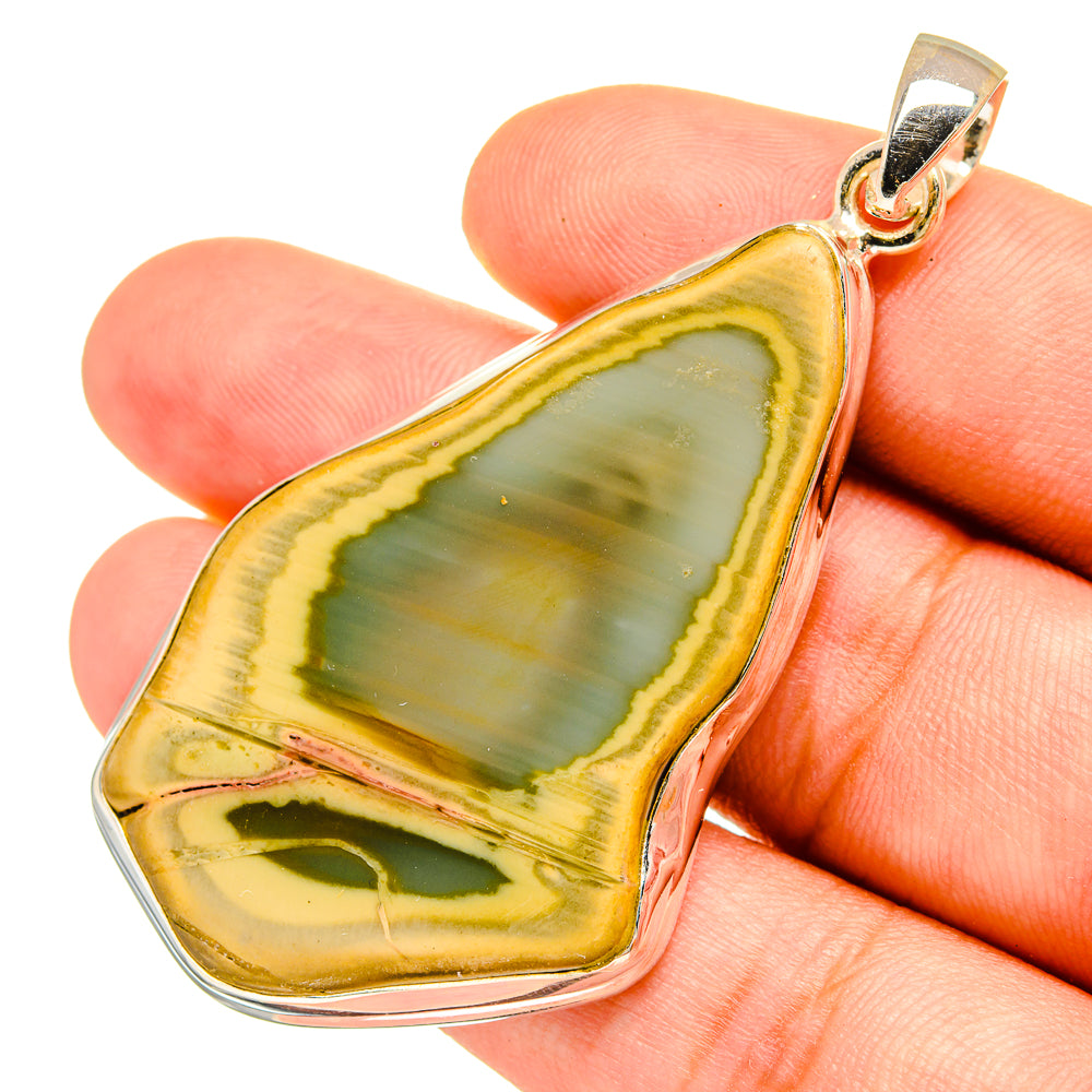 Teardrop jasper pendant on hand, green/yellow stone in 925 sterling silver setting