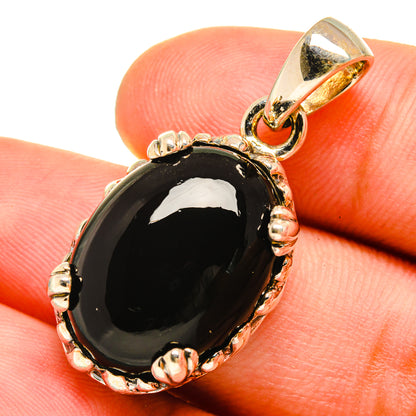 Black onyx pendant in oval bezel setting with bail, sterling silver tone accents