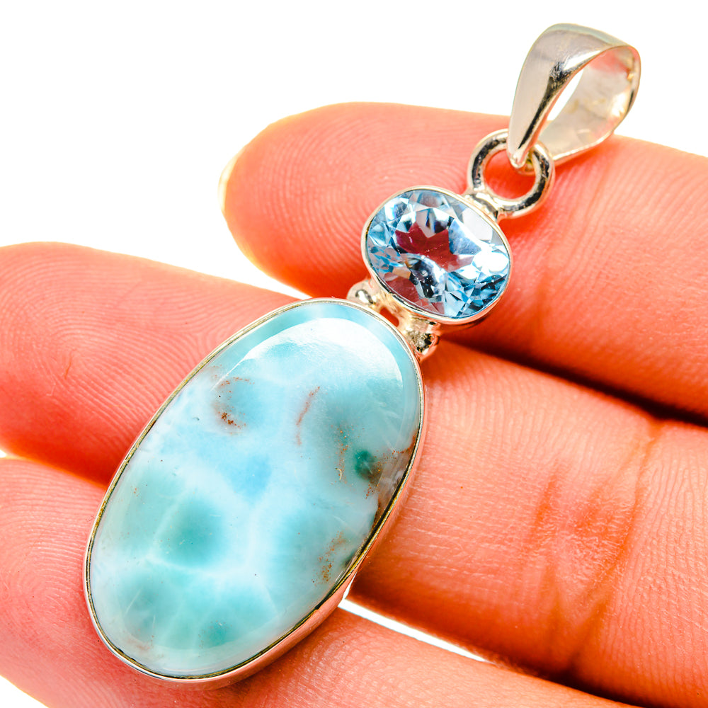 Sterling silver pendant close-up with oval larimar and round blue topaz stones