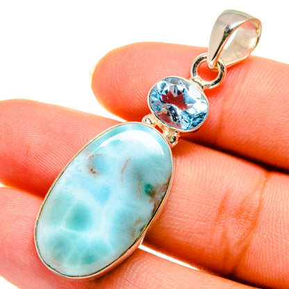 Sterling silver pendant close-up with oval larimar and round blue topaz stones
