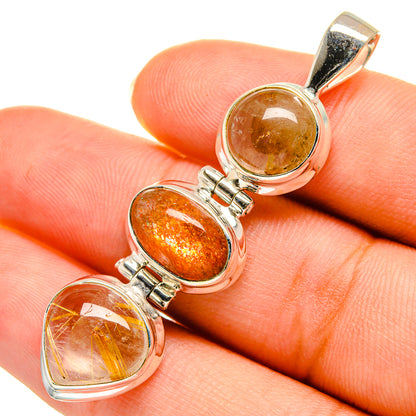 Rutilated quartz and sunstone pendant with three oval orange stones in silver bezel, close-up