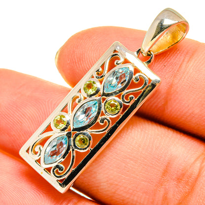 Sterling silver pendant with blue gemstones and green peridot accents, ornate rectangular frame