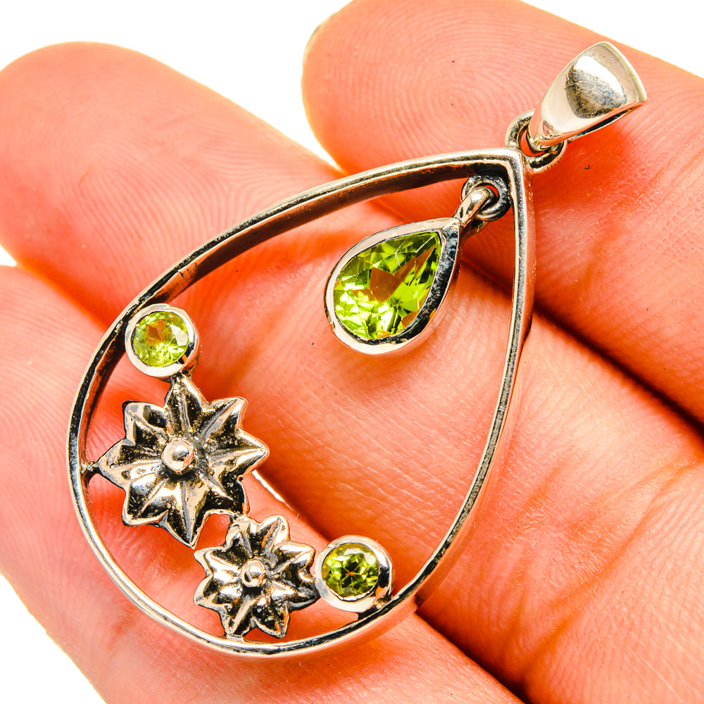 Sterling silver peridot teardrop pendant with three green stones and flower motifs, bail loop