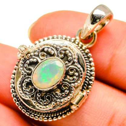 Round opal pendant in ornate silver filigree with green glow stone in bezel, bail loop top.