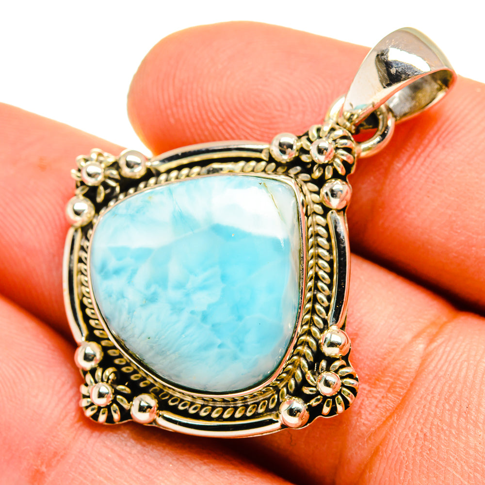 Larimar pendant with light blue teardrop stone and ornate gold-tone silver frame