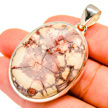 Sterling silver pendant with oval poppy jasper cabochon, warm cream and red mottling.