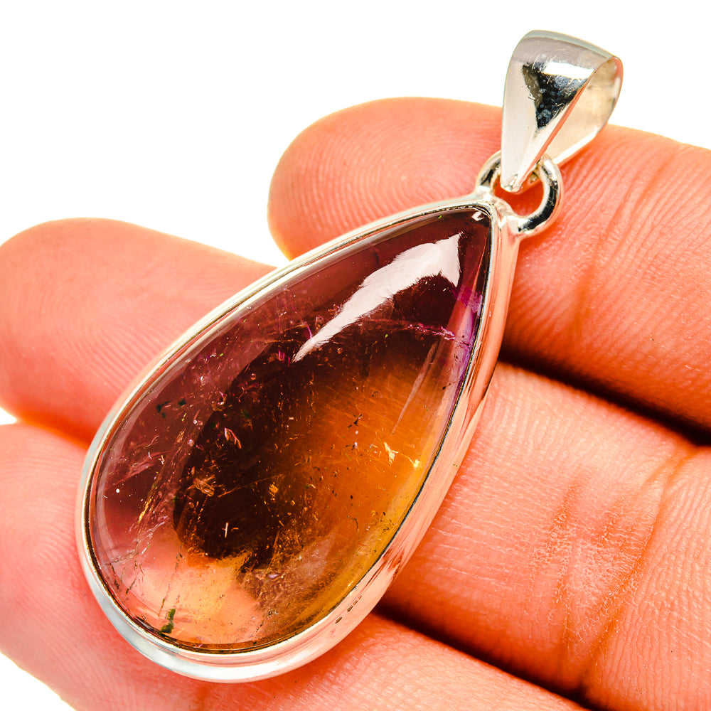 Teardrop ametrine pendant close-up on silver bail, amber and purple gemstone