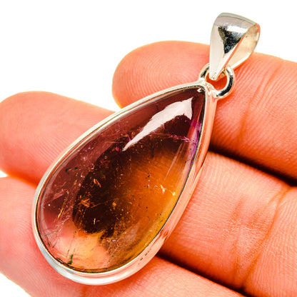 Teardrop ametrine pendant close-up on silver bail, amber and purple gemstone