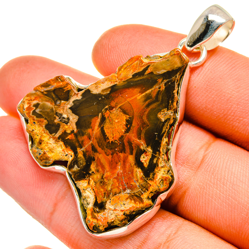 Petrified wood slice pendant with gold, black, and orange bands and sterling silver bail