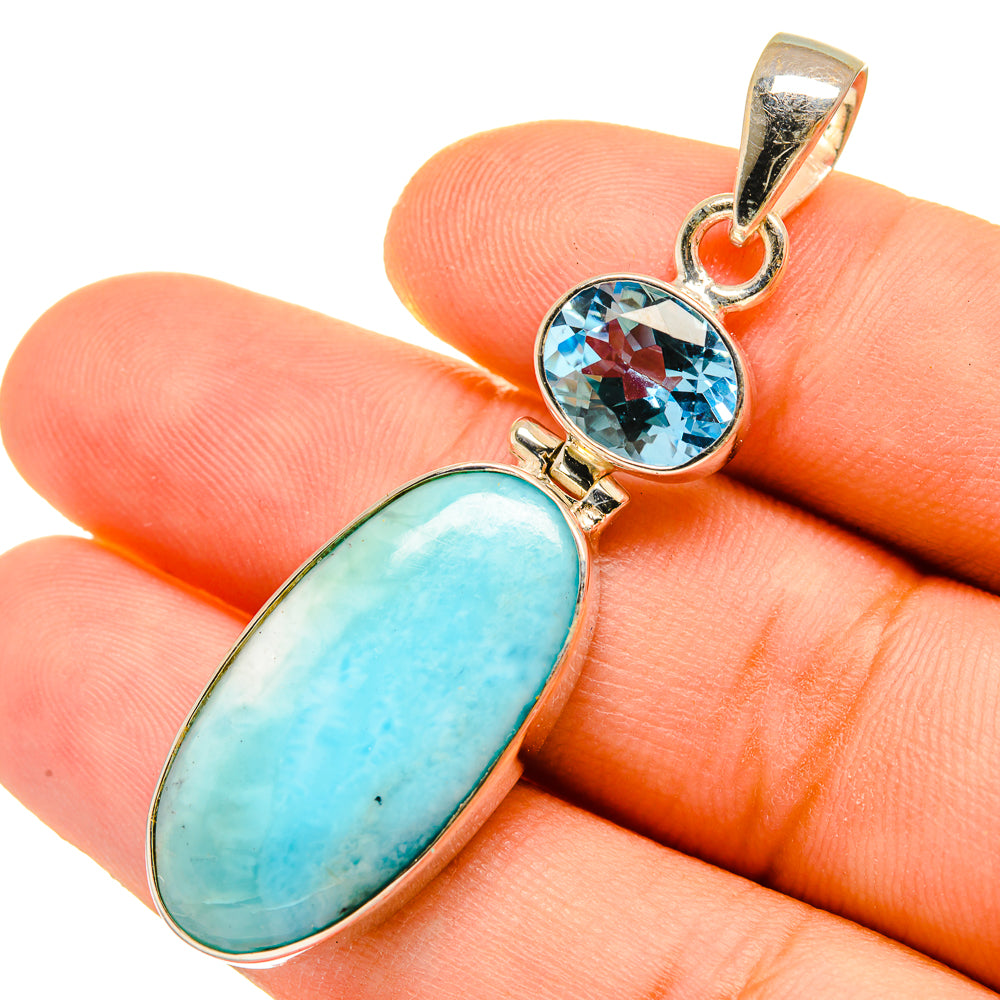 Silver pendant on fingers with oval Larimar and round blue topaz stones, bail