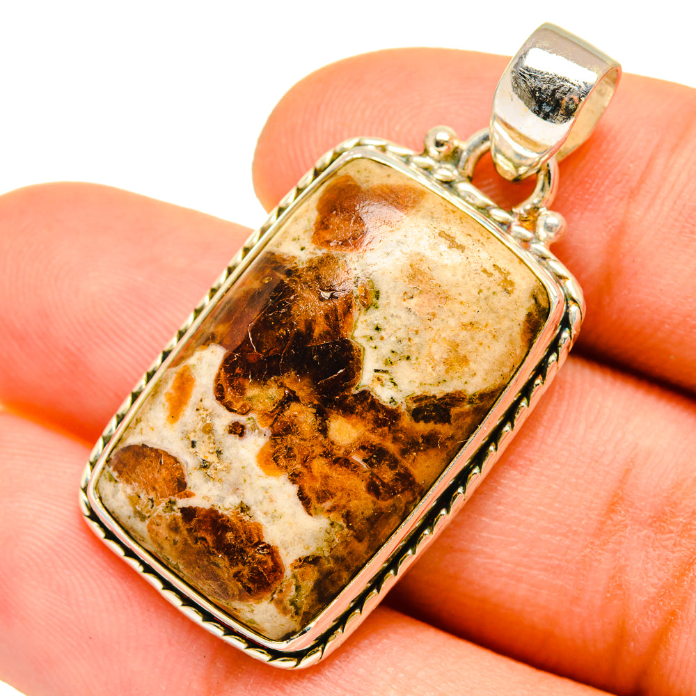 Muscovite stone pendant on finger, rectangular silver frame and loop bail