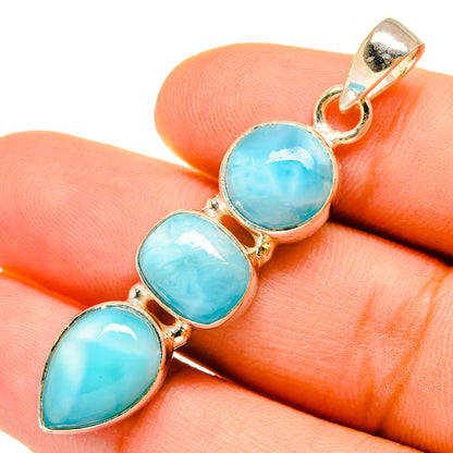Larimar pendant closeup on hand: three oval turquoise stones in silver setting