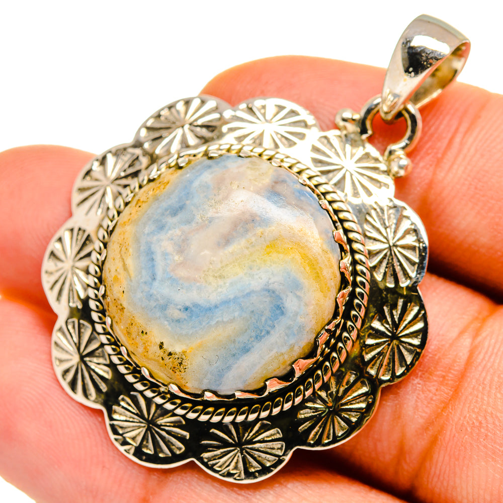 Oval blue scheelite pendant with ornate sterling silver halo and hanging bail