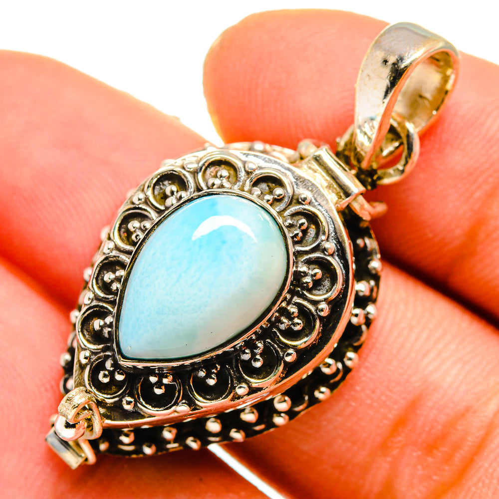 Larimar pendant close-up, oval light-blue stone in antique silver filigree frame