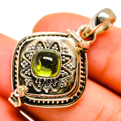 Sterling silver pendant with ornate frame and green gemstone, featuring a top bail.