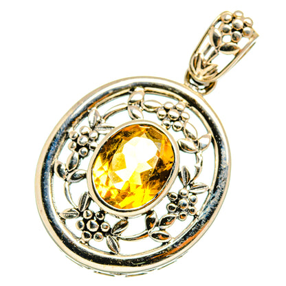 Round citrine pendant with faceted yellow stone, floral scrollwork and metal loop