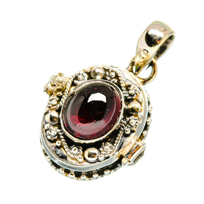 Round sterling silver pendant with dark red gemstone, ornate bezel and bail loop.