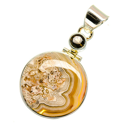 Round agate pendant with gold-tone bezel and dark gemstone, sterling silver bail