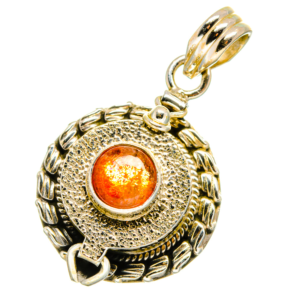 Round sunstone pendant with engraved swirl frame and orange cabochon, gold-toned bail