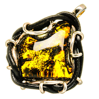 Amber pendant with black-and-gold stone, sterling silver bezel and bail loops