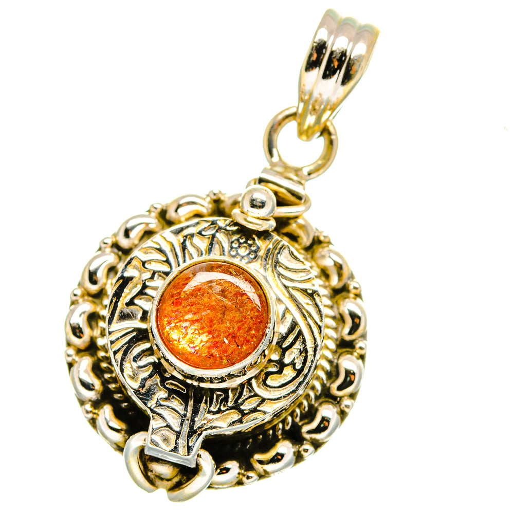 Sterling silver pendant with round orange gemstone set in an ornate silver frame